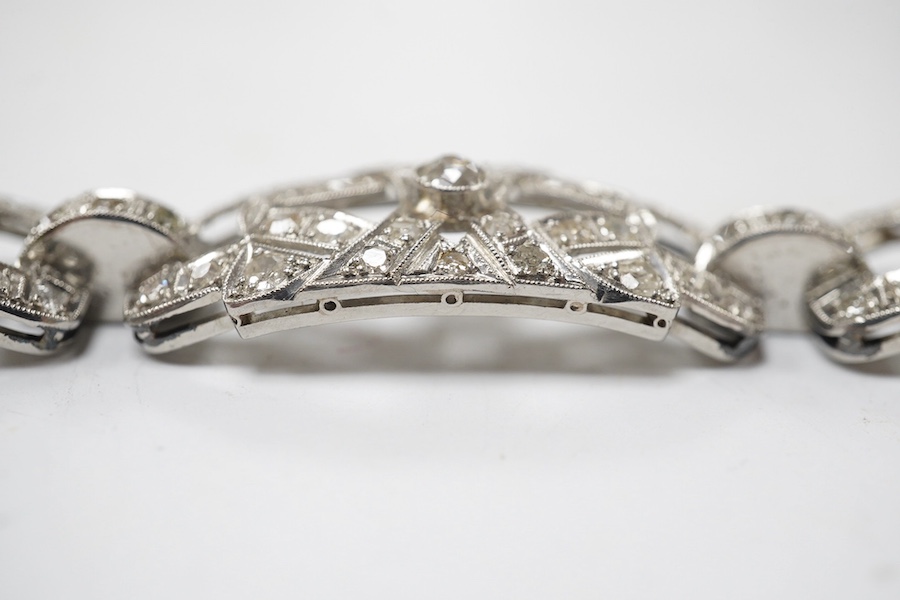 An early 20th century pierced platinum? and millegrain set diamond cluster bracelet, set with old round and eight cut stones, 17cm, gross weight 22.8 grams. Condition - fair to good